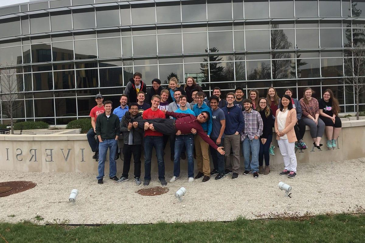 Actuarial Science program director Guangwei Fan with students in front of Gander Hall